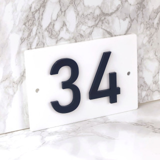Weißes Hausnummernschild mit schwarzen Ziffern